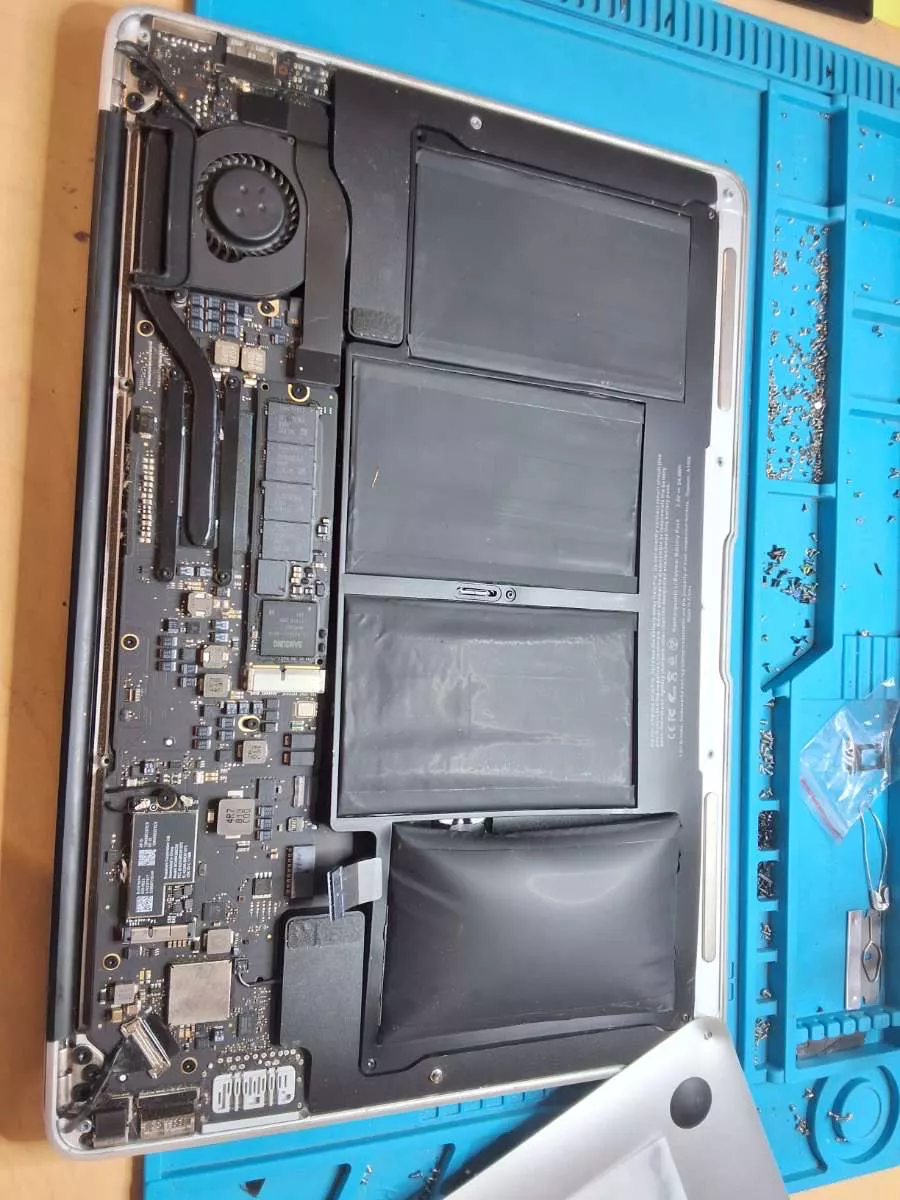 PC portable ouvert avec une batterie gonflée en cours de remplacement