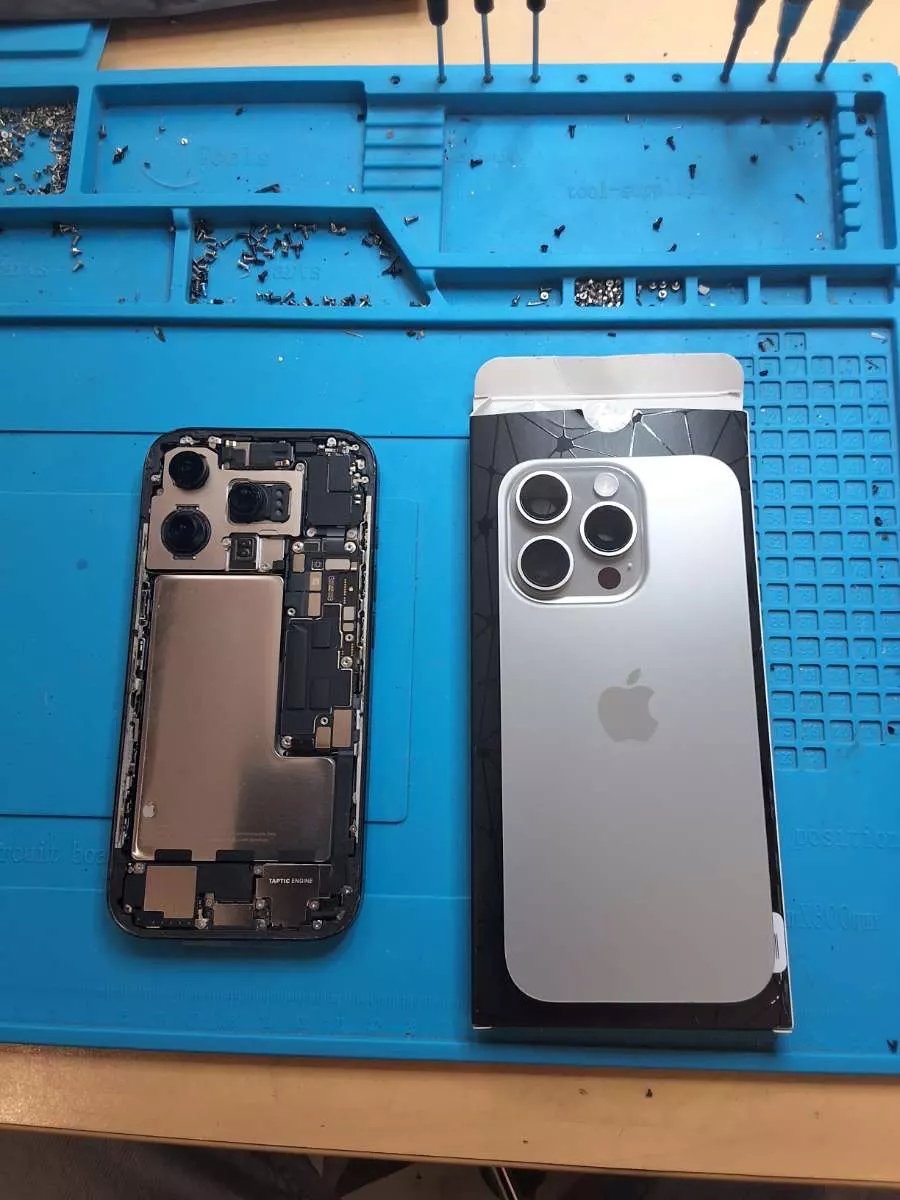 iPhone ouvert sur le tapis d'atelier pendant une réparation d'écran