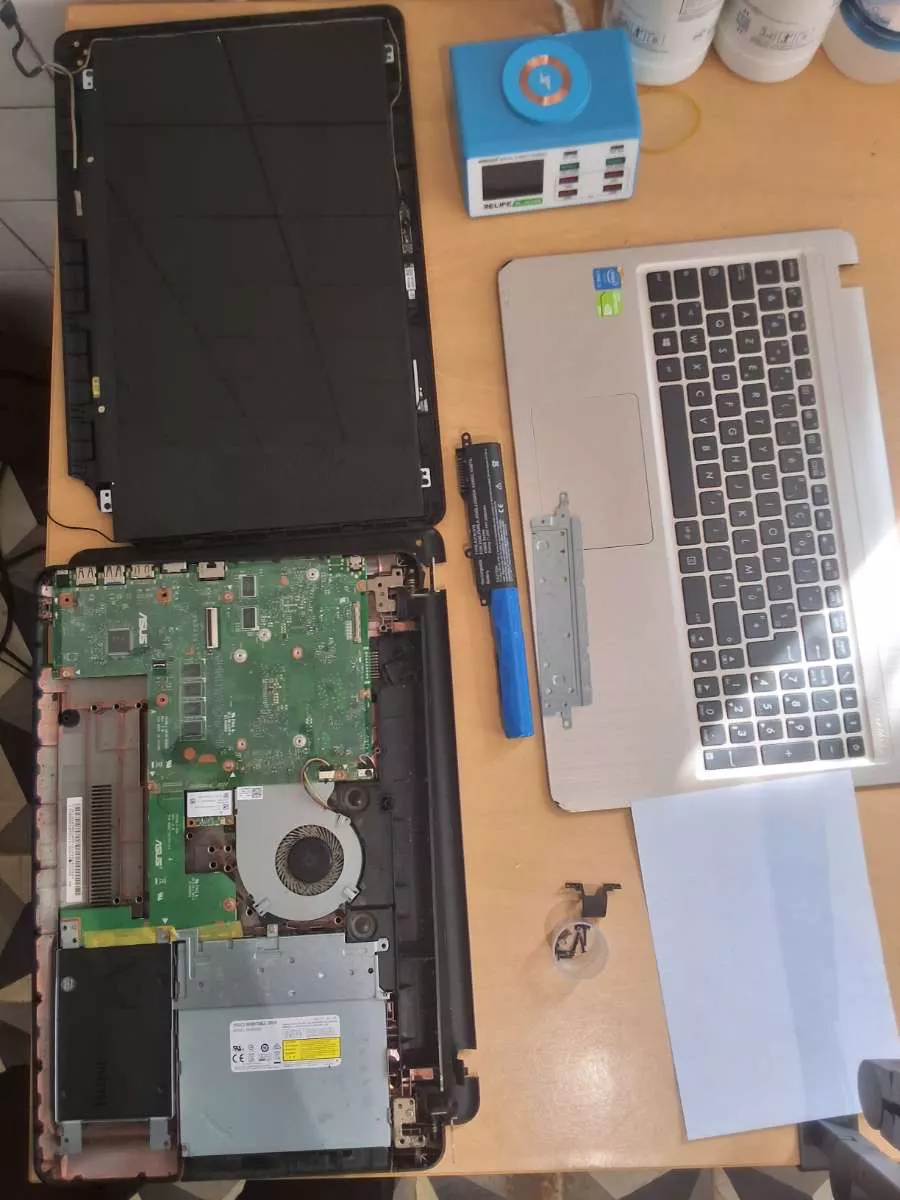 PC portable démonté sur le plan de travail de l'atelier